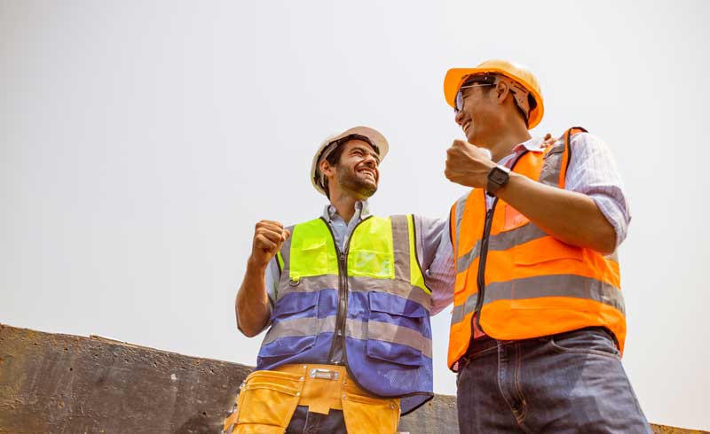 two construction workers standing next to eachother
